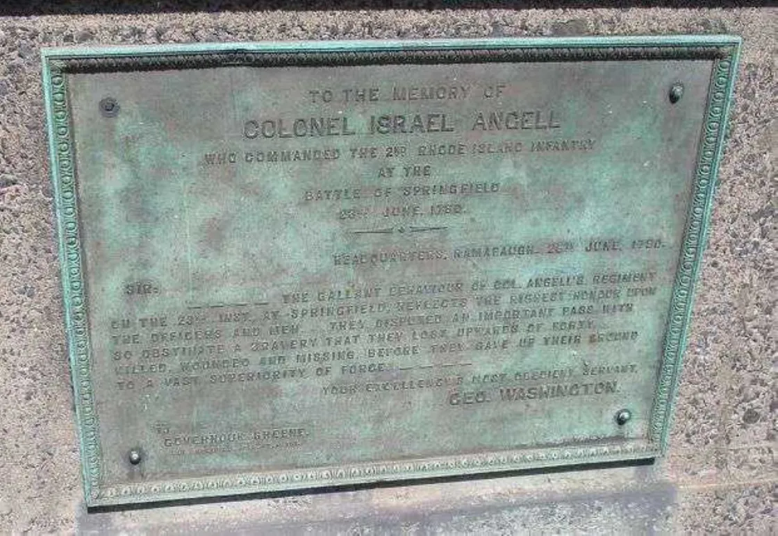 A bronze memorial plaque mounted on stone honors Colonel Israel Angell, featuring an engraved tribute letter from George Washington.
