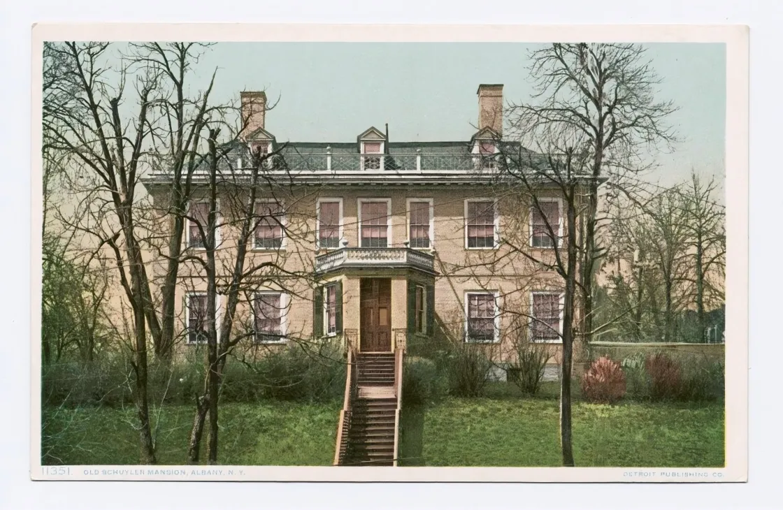 Postcard depicting colonial home showing two chimneys, dormer windows, covered entry and steps leading to front door.