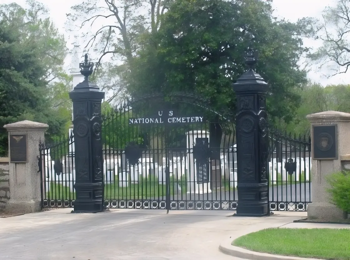 Black rod iron gate with stone columns and signage reading U.S. National Cemetery