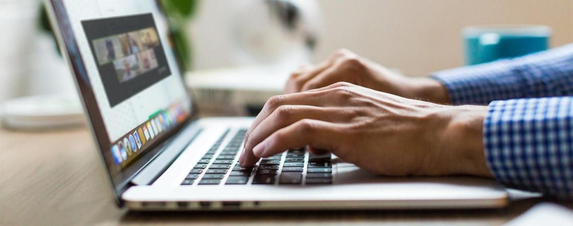An online participant watches a webinar on their laptop.
