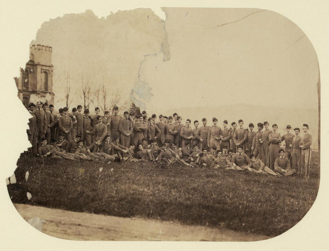 Vintage photo of large military group posing in rows on a hill