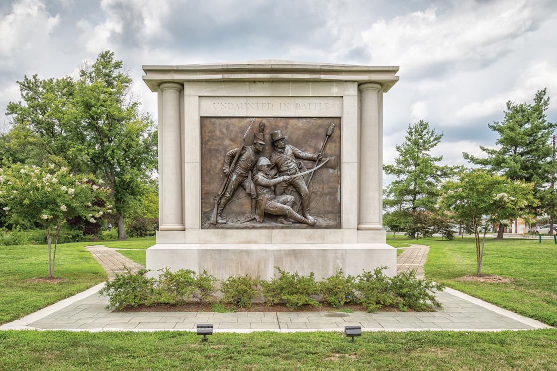 Stone memorial with a bronze bas-relief of three military officers