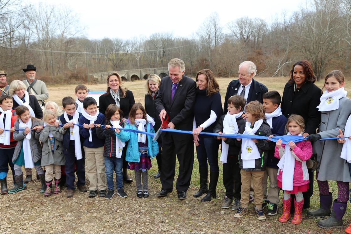 Photograph of a ceremonial ribbon cutting recognizing the preservation of the Goose Creek Bridge area
