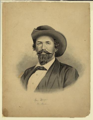 19th century portrait of man with a handlebar mustache wearing a western-type hat and a suit