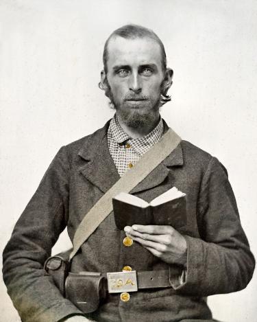 Photo of a Civil War Soldier reading a book.