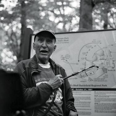 Ed Bearss gesturing at a sign on the Ball's Bluff Battlefield